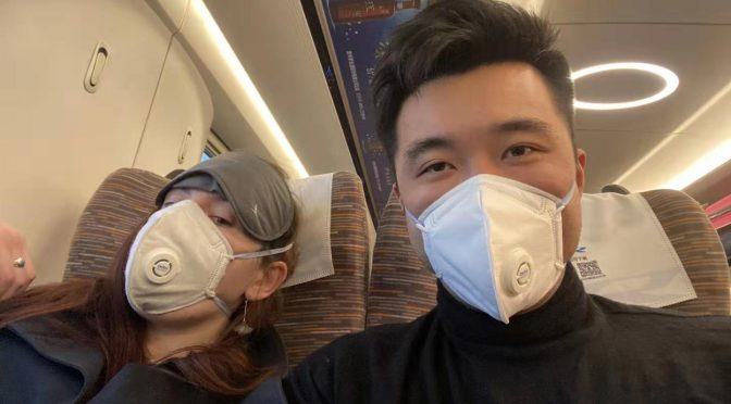 Two train travellers wearing facemasks